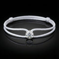 White leather bracelet with a central diamond on a black background