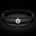Black cord bracelet with a diamond on a black background