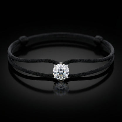 Black cord bracelet with a diamond on a black background