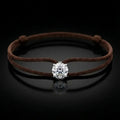 Brown cord bracelet with a diamond on a black background