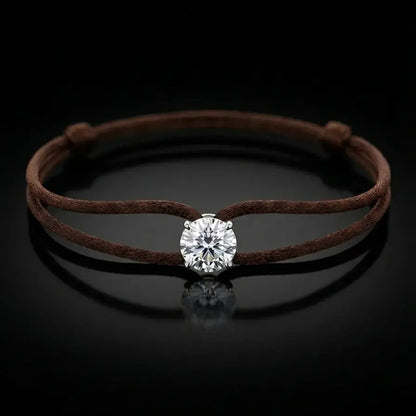 Brown cord bracelet with a diamond on a black background