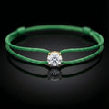 Green bracelet with a diamond on a black background
