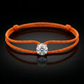 Orange bracelet with a diamond on a black background