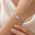 Blue bracelet with a diamond on a wrist against a neutral background