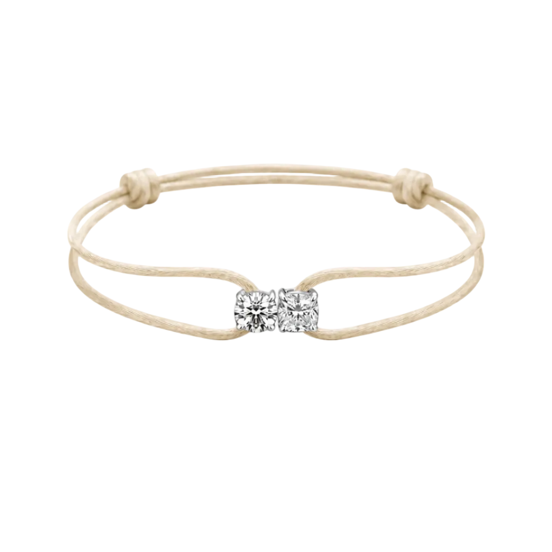 Beige bracelet with a diamond bow charm on a white background