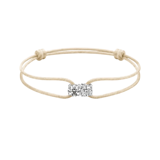 Beige bracelet with a diamond bow charm on a white background
