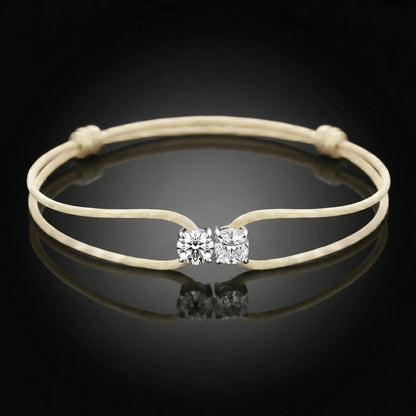 Beige bracelet with a diamond clasp on a black background