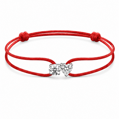 Red bracelet with a heart-shaped charm on a white background