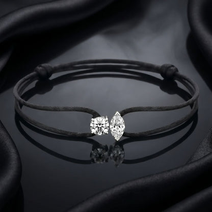 Bracelet with diamond-shaped earrings on a dark fabric background