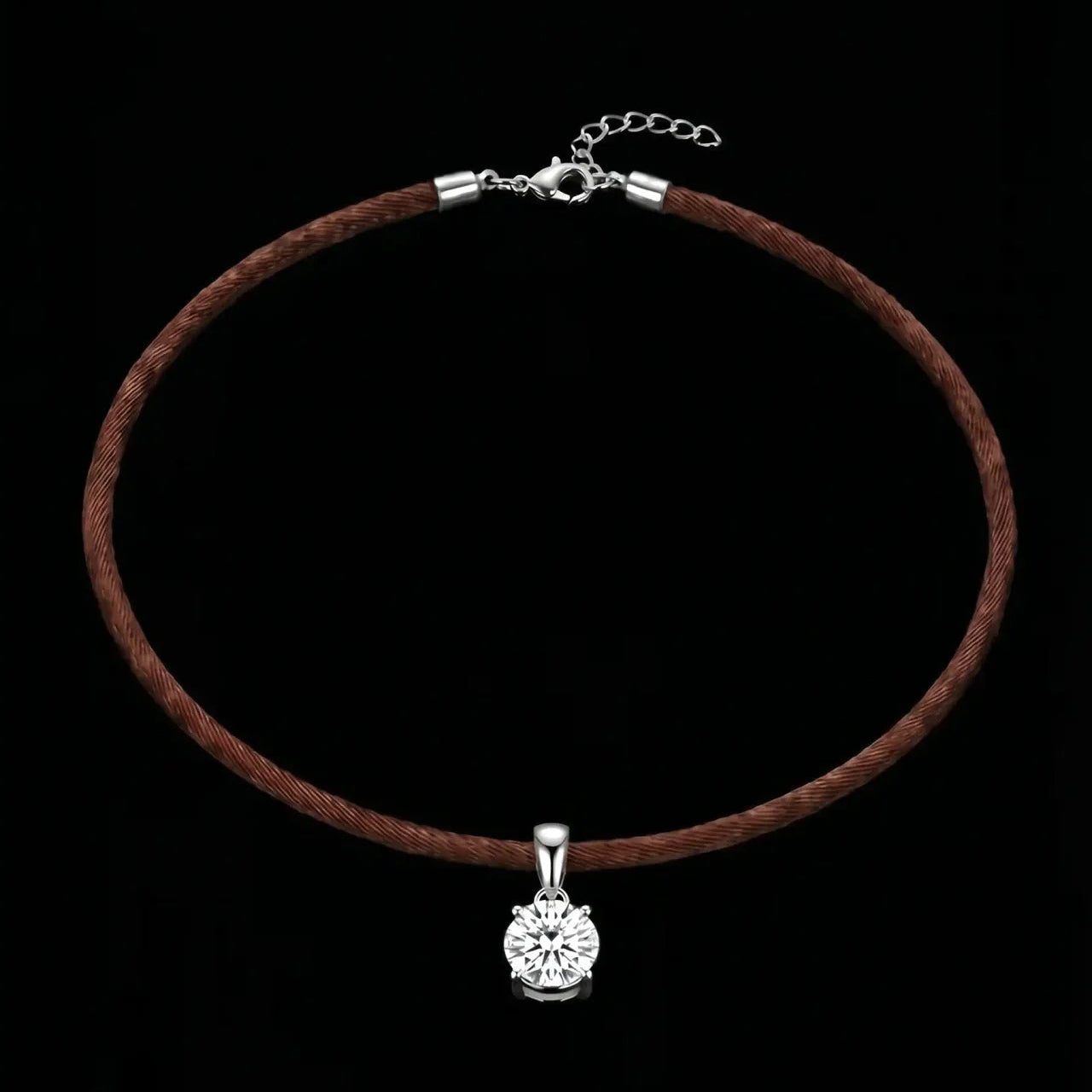 Brown cord necklace with a silver pendant on a black background