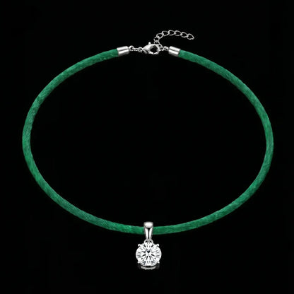 Green satinchoker necklace with a silver pendant on a black background