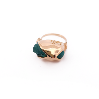 Gold ring with green gemstone on a white background