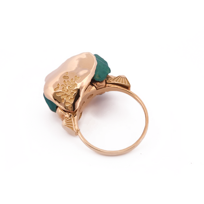 Gold ring with a green gemstone on a white background