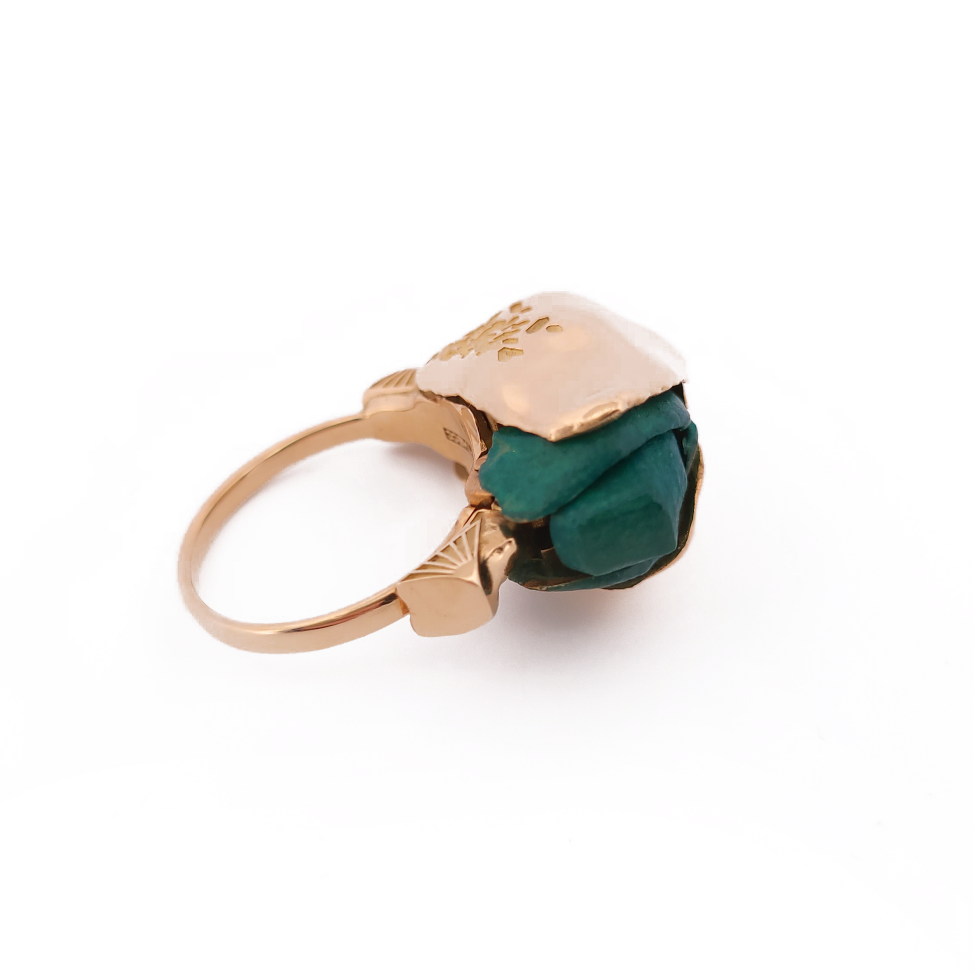Gold ring with a green gemstone on a white background