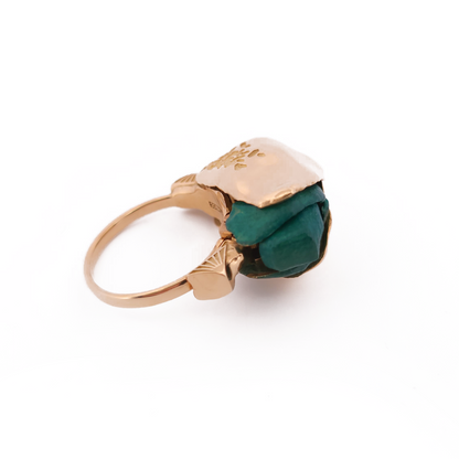 Gold ring with a green gemstone on a white background