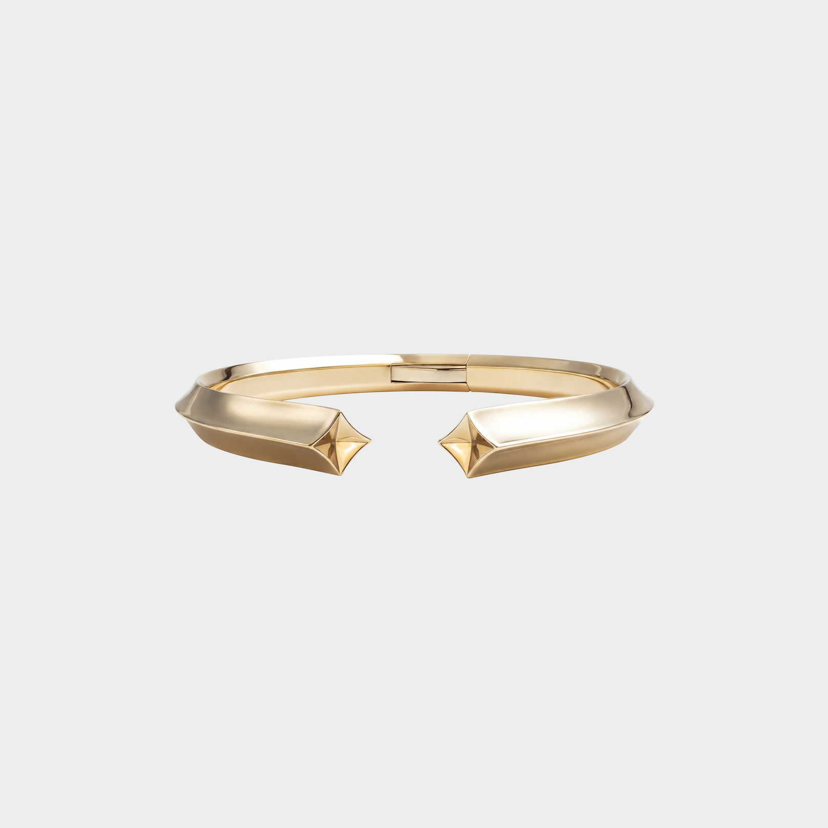 Gold bracelet with geometric design on a light gray background