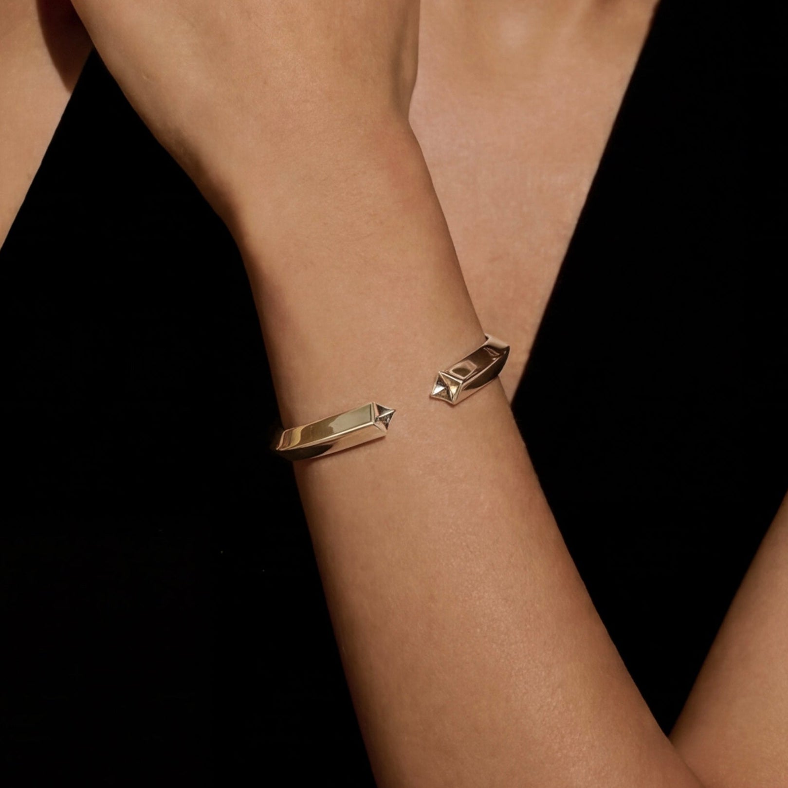 Woman wearing gold jewelry against a warm brown background