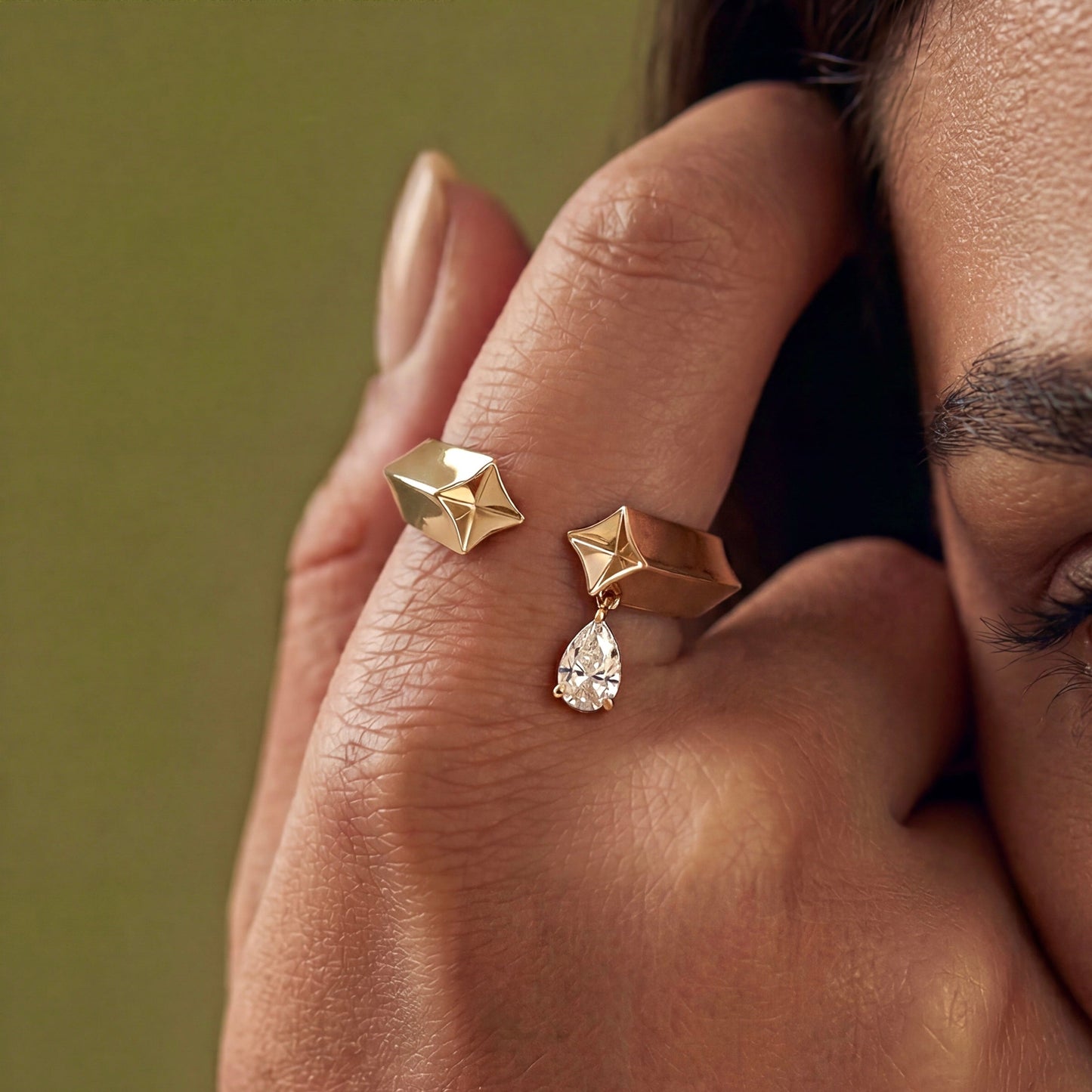 Gold ring with geometric design and teardrop-shaped diamond