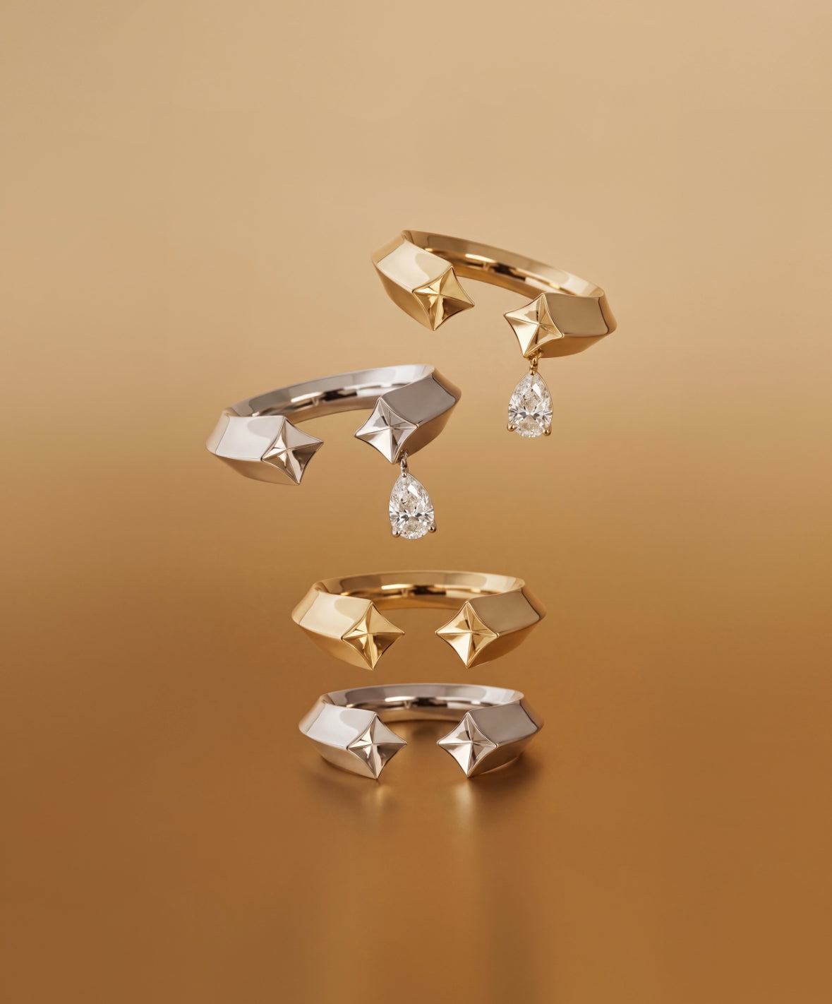 Set of gold rings with geometric designs and diamond-like stones on a brown background