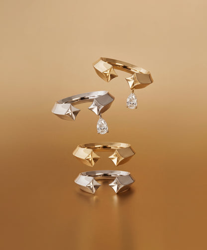 Set of gold rings with geometric designs and diamond-like stones on a brown background