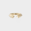 Gold ring with geometric design on a light gray background