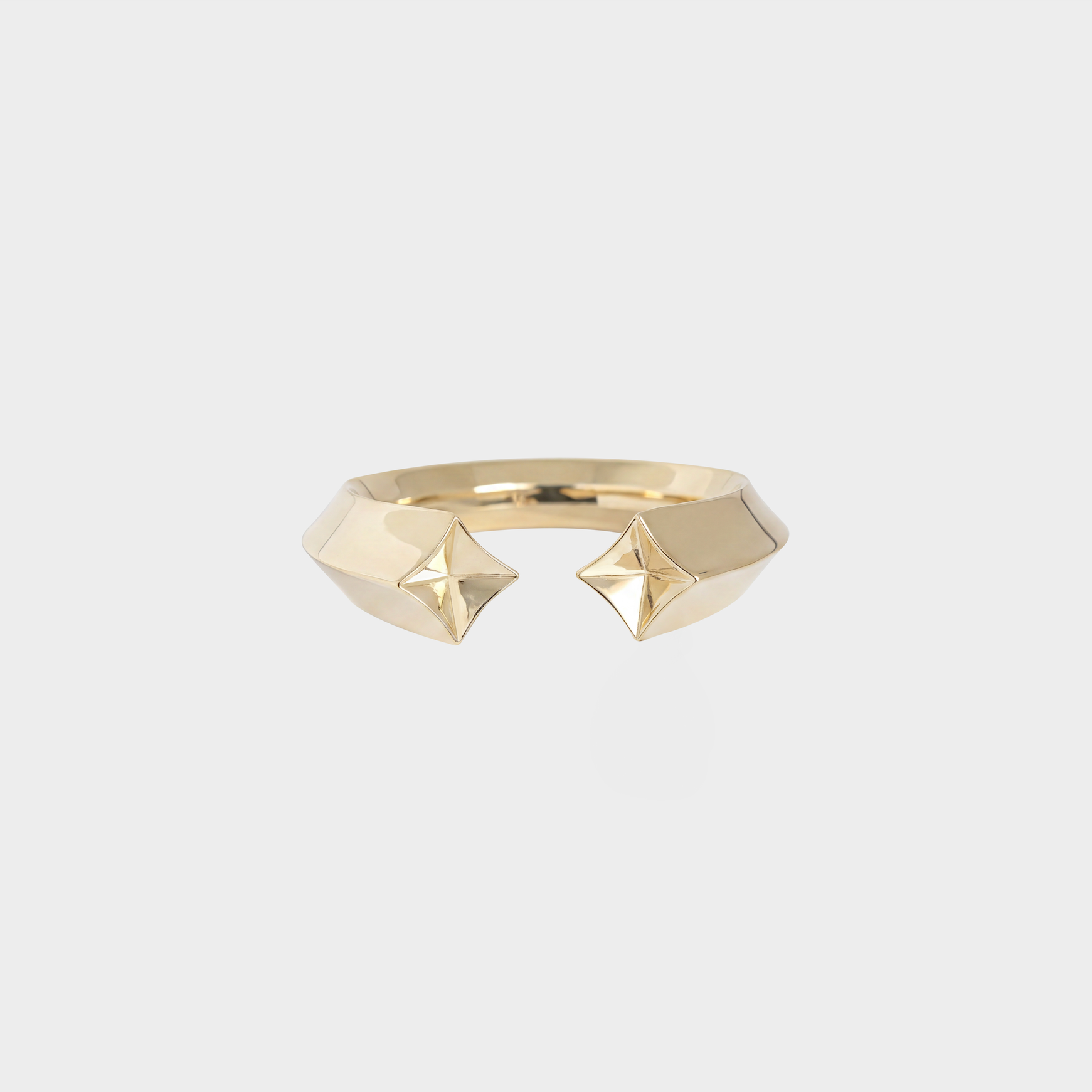 Gold ring with geometric design on a light gray background