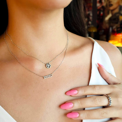 Close-up of a woman wearing a necklace and ring with a blurred background