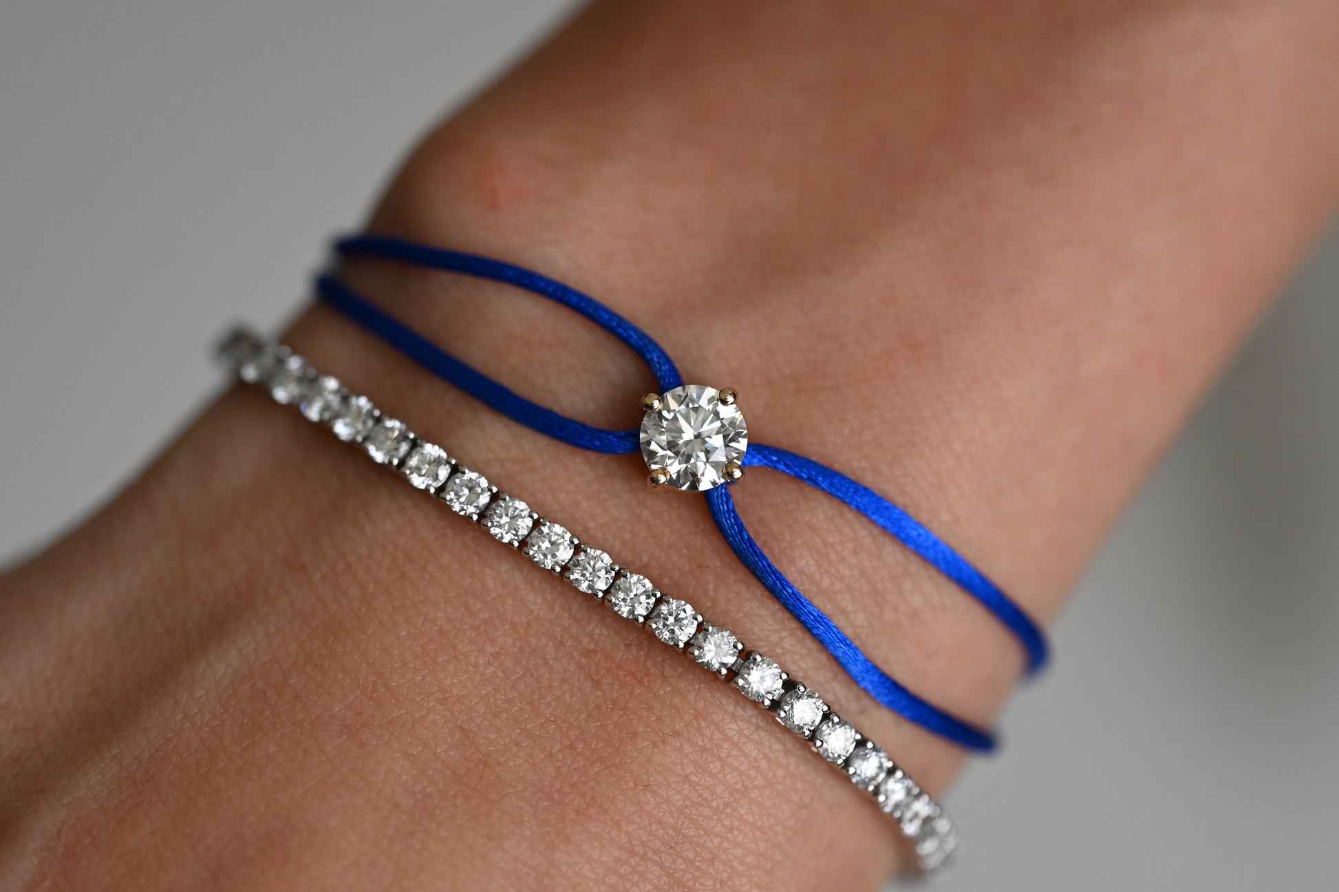 Dennis Luxe Satin Cord Bracelet in blue, stacked with a tennis bracelet