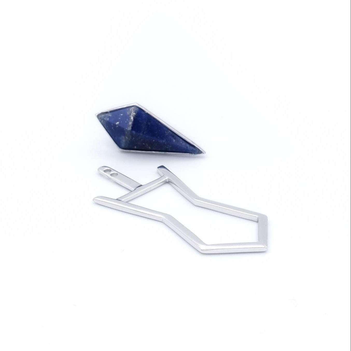 Gold earring with a blue gemstone on a white background