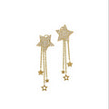 Gold star earrings with chain drops on a white background