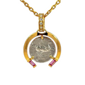 Gold pendant with a coin and pink gemstones on a white background