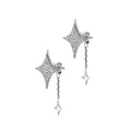 Star-shaped silver earrings with dangling elements on a beige background