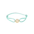 Turquoise bracelet with a gold charm on a white background