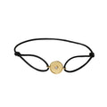 Black bracelet with a gold clasp on a white background