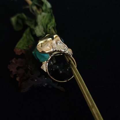 Gold ring with green gemstone on a black background