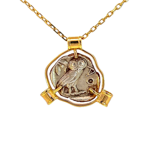 Gold necklace with a coin pendant featuring an owl design on a white background