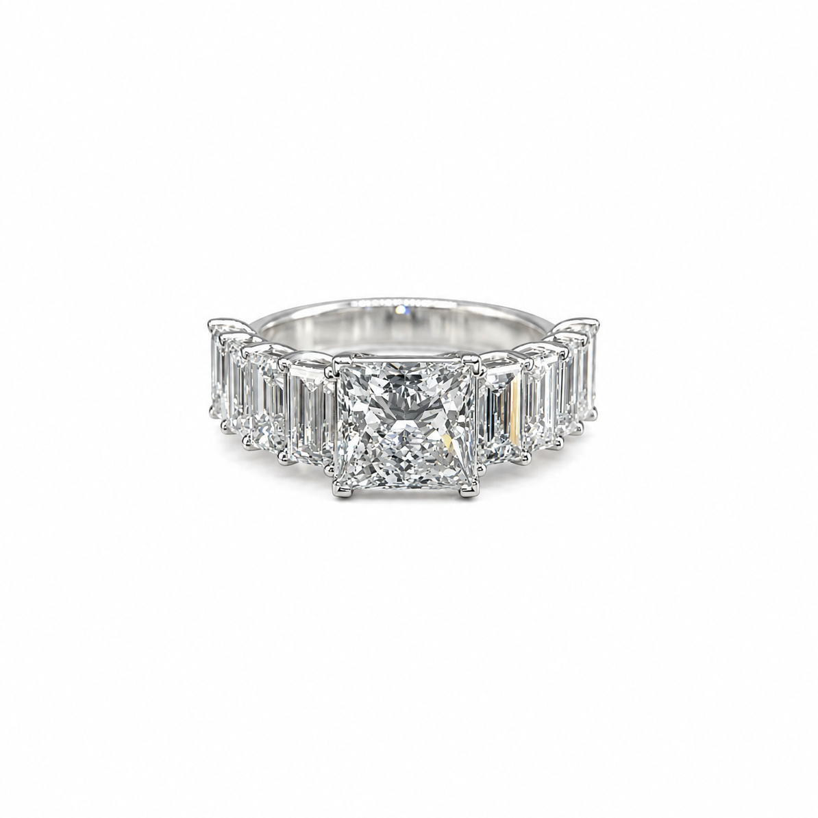 Diamond ring with emerald-cut stones on a white background