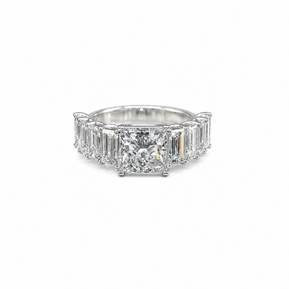 Diamond ring with emerald-cut stones on a white background