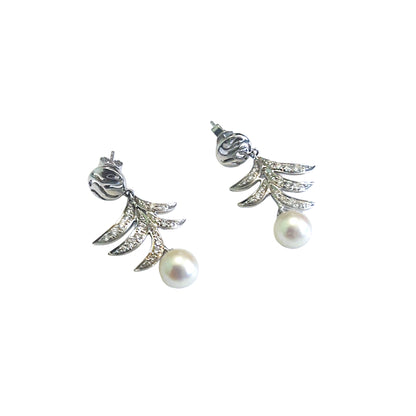 Pair of gold earrings with pearl drops on a white background