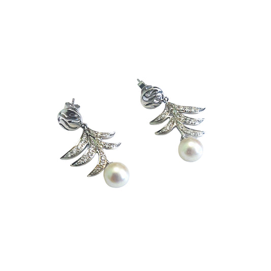 Pair of gold earrings with pearl drops on a white background