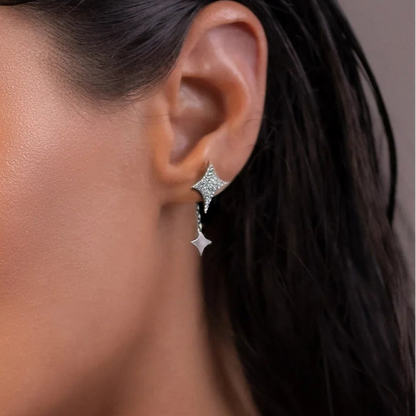 Close-up of an ear wearing a star-shaped earring with a blurred background