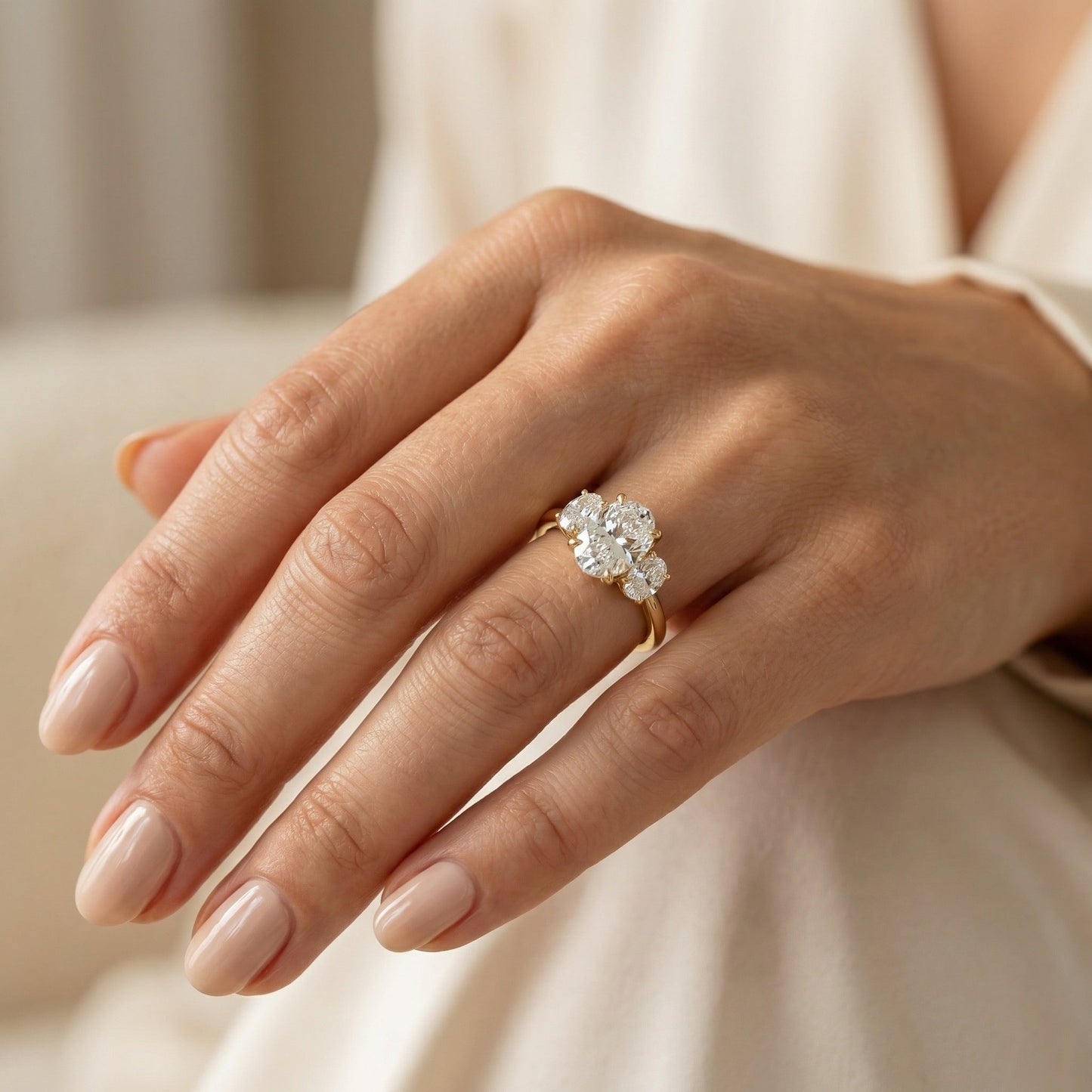 White Drop three stone oval diamond ring worn in an original lifestyle image